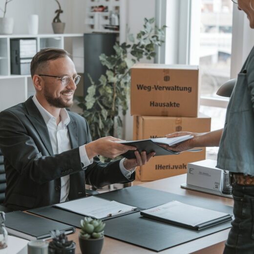 Ehemalige Verwalterin übergibt Unterlagen an WEG-Vertreter im Büro